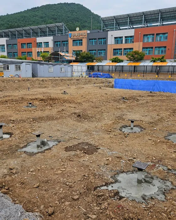 관입을 마치고 그라우팅한 말뚝 머리에 캡 플레이트를 올린 학교 증축 현장
